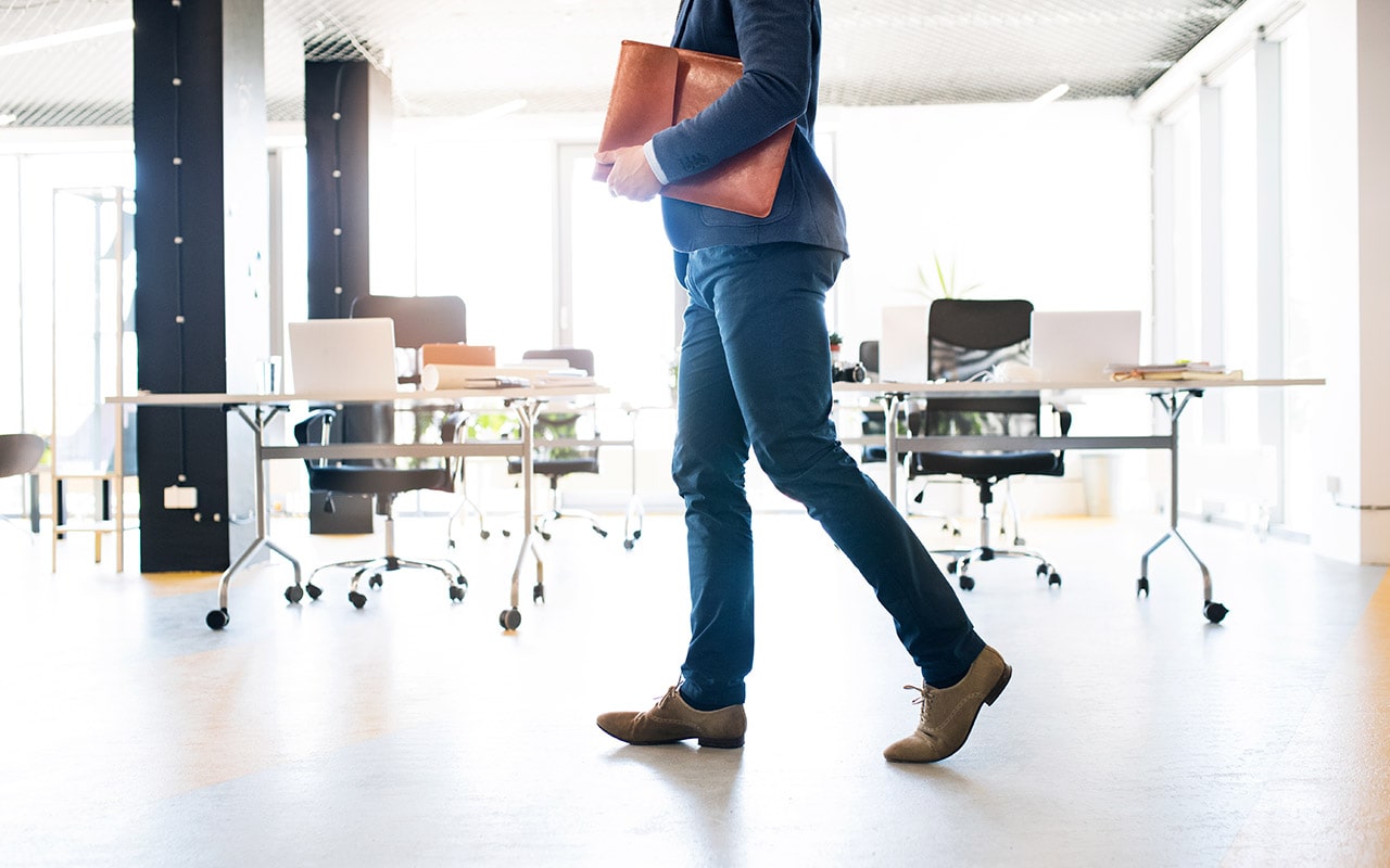 businessman-walking-in-an-office-min businessman walking in an office min